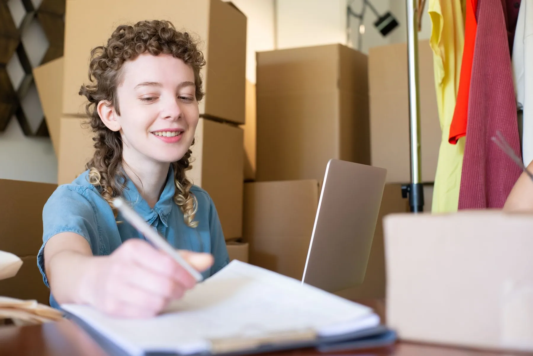 A home business owner packing orders with a laptop