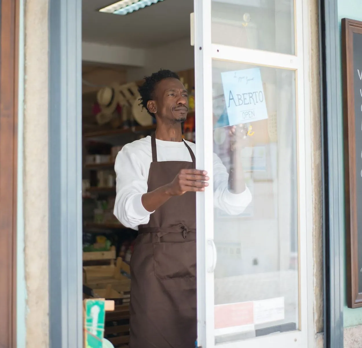A shop owner opening his door for the day